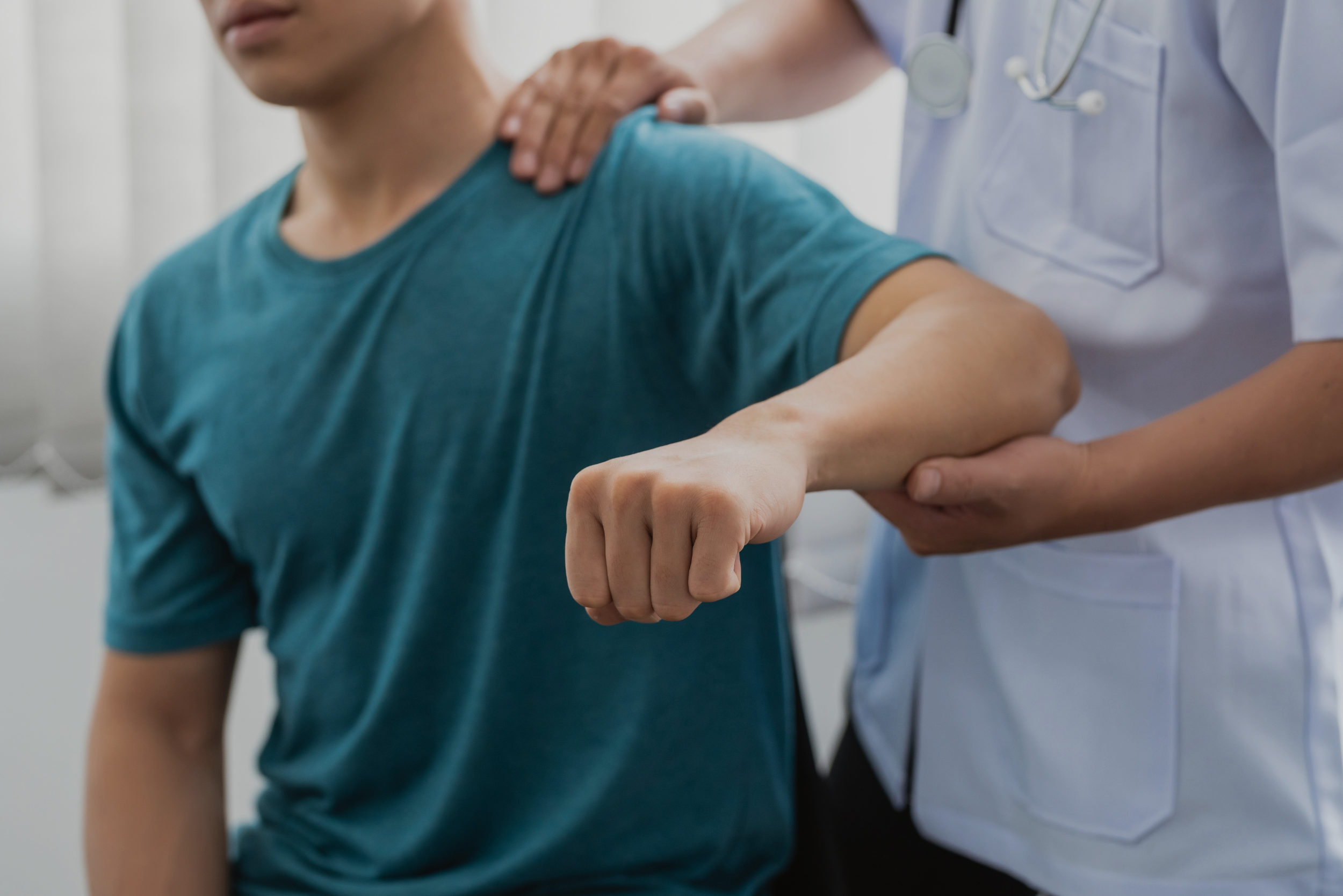 chiropractor lifting patient arm