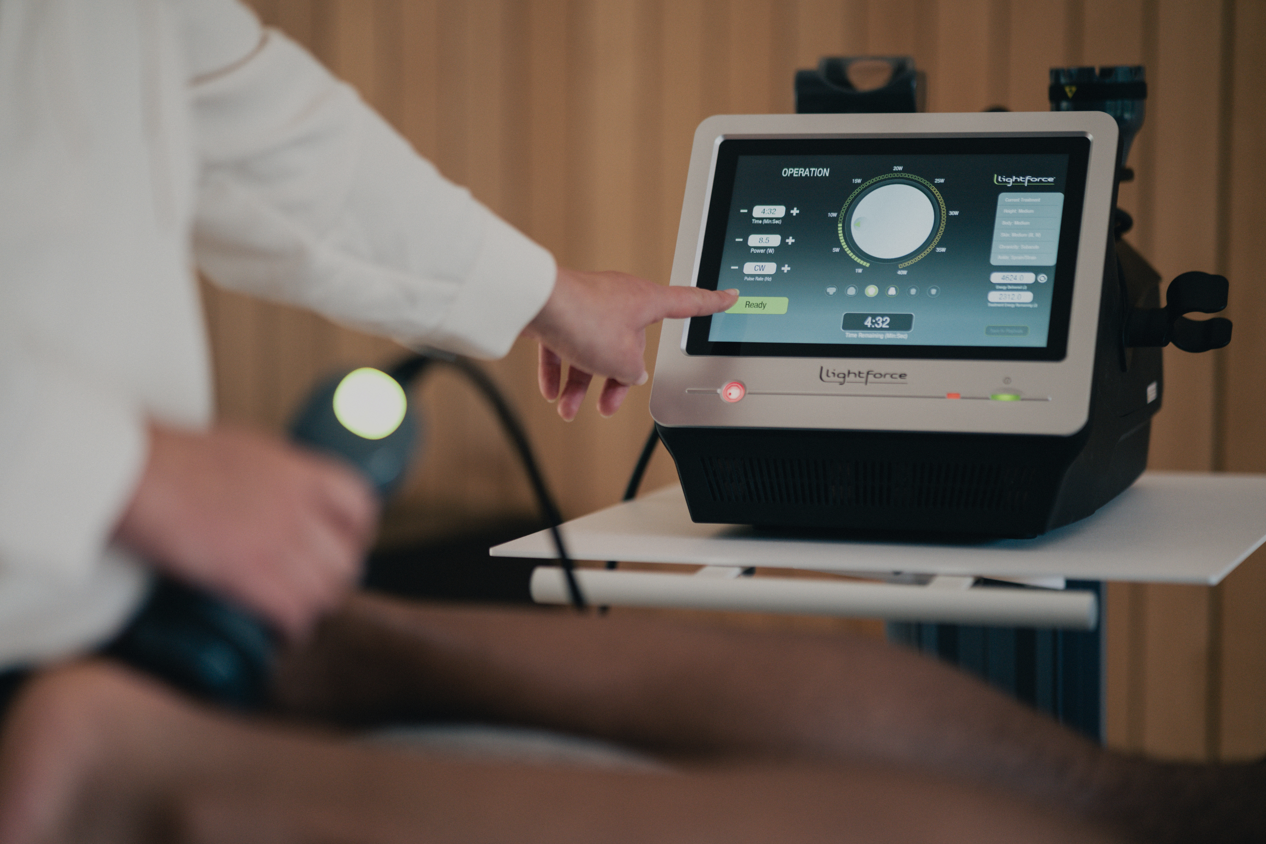 doctor's hand reaching towards laser to change program