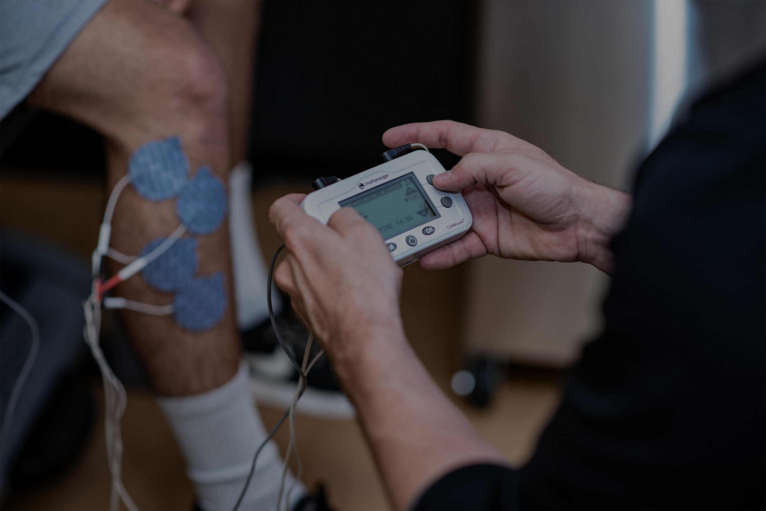 electrodes on patient leg, using electrotherapy device