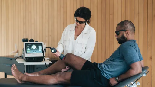 clinician using laser on patient knee