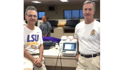 two men standing with laser module between them