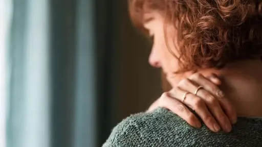 woman rubbing her shoulder