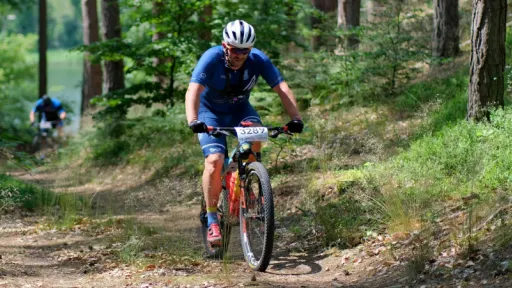 man riding bike through forest