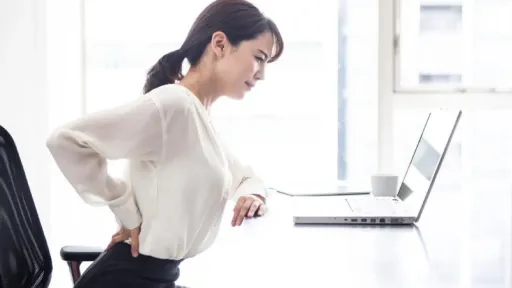 woman sitting in an office with back pain