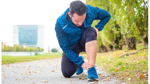 man in athletic gear with ankle pain