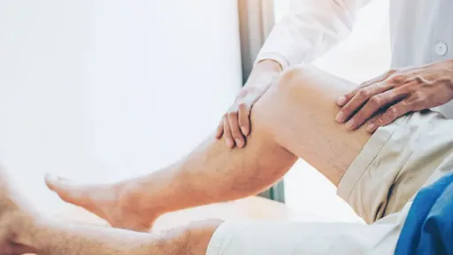 doctor palpating patient knee