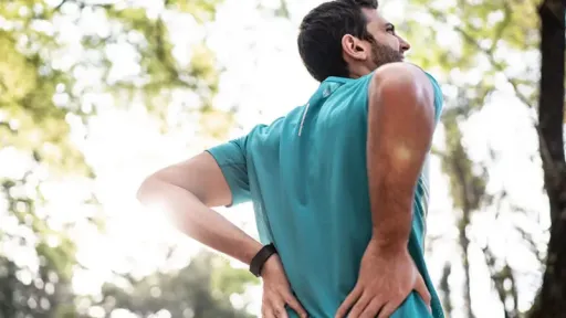 man looking upwards with his hands on his back