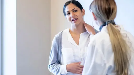 woman with hand on neck talking to doctor