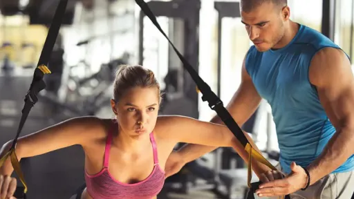 woman exercising with bands, coach helping her