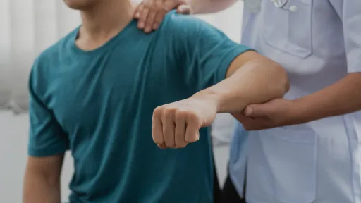 chiropractor lifting patient arm
